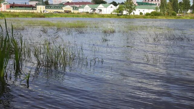 View from the water at Valdai Iversky Svyatoozersky Virgin Monastery for Men. Selvitsky Island, Valdai Lake. View of the Valdai Iversky Bogoroditsky svyatoozersky monastery. Sunny June day,