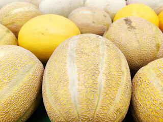 Cantaloupe and honeydew melons on display in grocery store or farmers market.