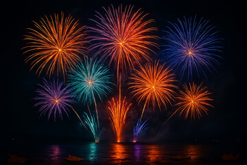 Vibrant display of colorful fireworks exploding in the night sky reflecting on dark water