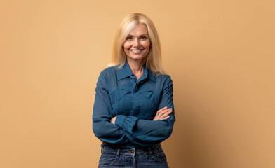 Stylish confident adult 50 years old attractive blonde woman standing arms crossed looking at...