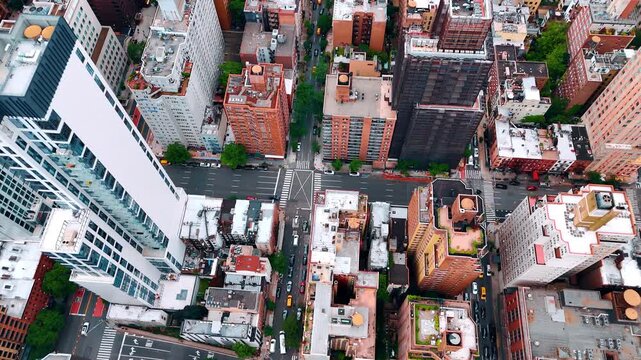 Flying over the roofs of diverse buildings in the metropolis. Streets of New York, USA with transport on.