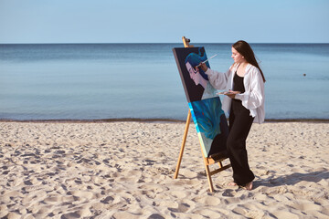 Young female artist painting on canvas at serene beach, embracing creativity and tranquility. Ocean...