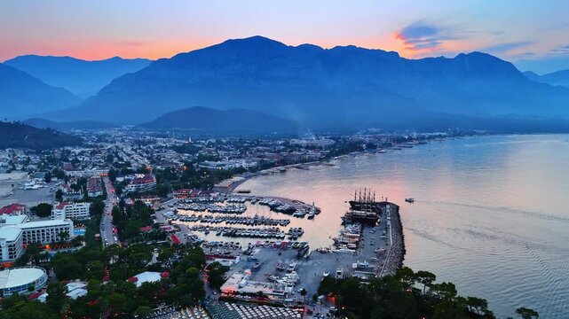 Dusk time in beautiful resort Fethiye, Turkey. Numerous yachts are at the berths. Mountain silhouettes in the backdrop.