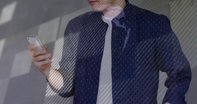 Man scrolling phone plans for review, camera shifting upward casting striped light across face