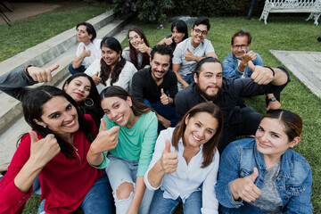 Latin multigenerational people with thumbs up and having fun in a public park in Mexico Latin America, portrait of hispanic people 