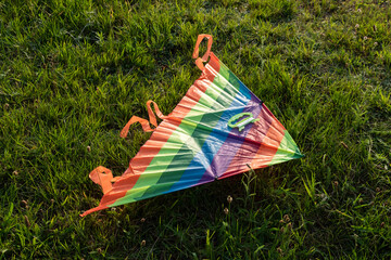 A colorful kite lies on the grass.
