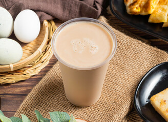 Creamy Iced Milk Tea in a Plastic Cup on a Burlap Background side view of hong kong food