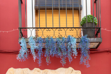 Fragment of a balcony with iron railing and hanging lavender bouquets