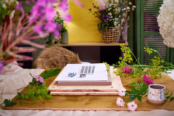 Flower pressing kit surrounded by fresh summer flowers. DIY botanical project in cozy home setting...