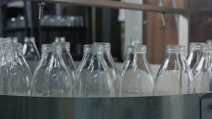 Empty glass bottles passing on industrial conveyor