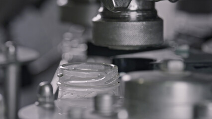 Automated machine closing yogurt jar lids in dairy