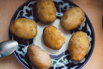 Boiled potatoes in the skin on a large plate. High quality photo