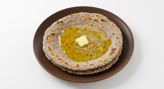 traditional Indian Gujarati food roasted flat bread bajra roti or bhakri, jawar roti with butter or ghee on earthen clay tawa pan, white background, top view