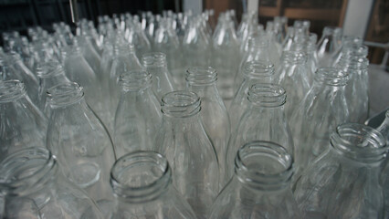 Empty glass bottles waiting on conveyor belt for