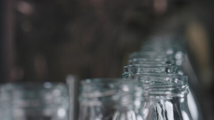 Empty glass jars moving on conveyor belt in food