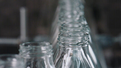 Empty glass bottles moving on industrial conveyor