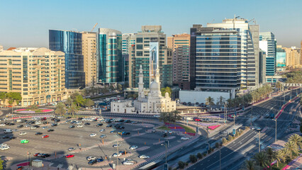 Mosque near Dubai Creek surrounded by modern buildings and busy traffic street timelapse