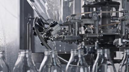 Industrial bottling machine pouring milk into