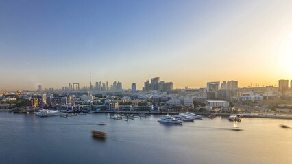 Dubai creek landscape timelapse with boats and ship and modern buildings in the background during sunset