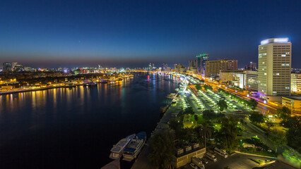 Dubai creek landscape day to night timelapse with boats and ship near waterfront