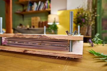 Handmade wooden flower press labeled "Wild Flowers", surrounded by fresh botanicals. A rustic tool for preserving nature through pressing and drying