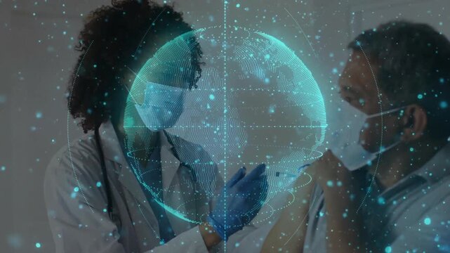 Physician drawing vaccine and injecting patient in exam activating rotating globe for immunization