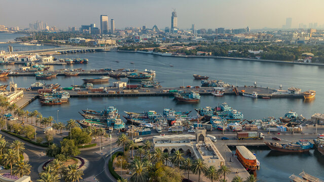 Dubai creek landscape timelapse with boats and ship in port and modern buildings in the background during sunset