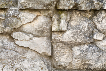Textured stone wall featuring rough and smooth surfaces, showcasing natural variations in color and shape, ideal for architectural and design projects