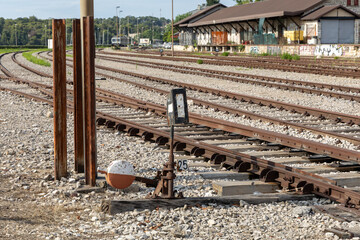 Railway tracks stretch into the distance with a vintage signal post and gravel foreground, showcasing the essence of transportation infrastructure