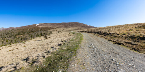 Panoramic view of idyllic mountain landscape in Austria. Smooth mountains with hiking trail at Hochrindl pasture.