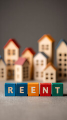 Colorful alphabet blocks spelling rent in front of miniature houses image