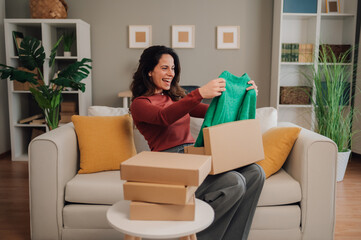 Woman enjoying unboxing new fashion purchase at home