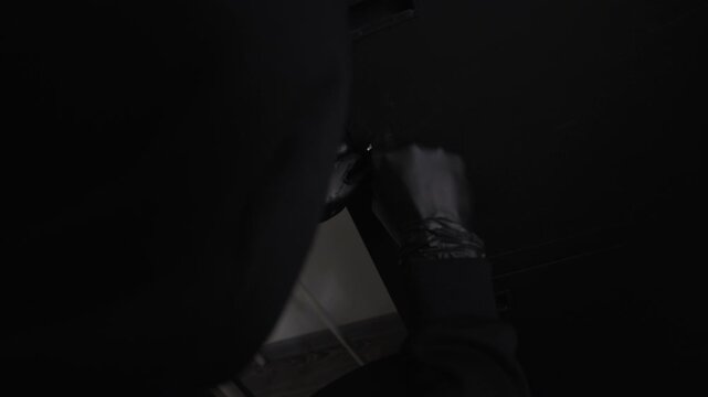 Close up on gloved hands of unrecognizable criminal cracking deposit safe lock with lockpicks while robbing corporate office