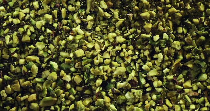 Falling Crushed Pistachios in Slow Motion of Green Nut Granules Dropping and Spreading, Ideal for Gourmet Food, Baking Ingredients, and Organic Snack Concepts