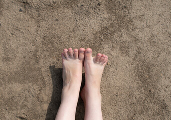 Naked female feet on dry ground