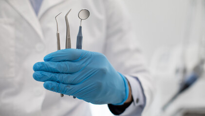 Unrecognizable Dentist Doctor In Blue Sterile Glove Holding Dental Tools In Hand, Demonstrating Mouth Mirror, Probe And Stainless Tweezers, Creative Banner For Quality Stomatological Services