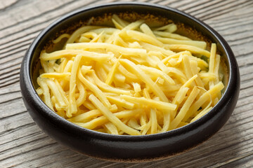 Canned bamboo shoots in bowl.  Rustic wooden table.  An important ingredient in Asian cuisine. 