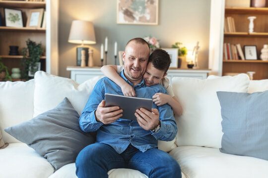 Happy, tablet and father with child in home for watching movies, cartoons and online entertainment. Family, love and dad with son on digital tech for internet, video call and relax on weekend on sofa.