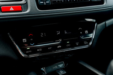 Close-up of Honda car climate control panel with digital temperature display, air conditioning buttons and mode indicators – modern automotive interior with touch controls and sleek black finish