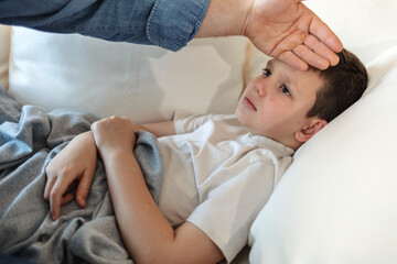 Home, bed and sick kid with hand of parent for high temperature or flu and ill at night. House, people and fever in bedroom with allergy, cold and virus or disease with care, support and trust.