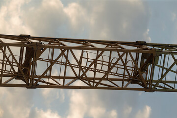 A large and imposing metal structure stands tall against a backdrop of an overcast, cloudy sky, creating a dramatic scene