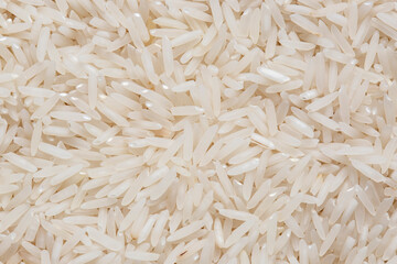 Pile of raw basmati rice grains background backdrop. Oriental food ingredients concept.