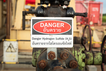 Danger of Hydrogen sulfide gas caution sign (In English and Thai text), the label on the gas and...