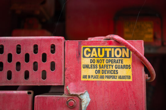 Caution safety sign of moving part inside the machine, dangerous for hand and finger injury. Industrial equipment safety information, close-up.