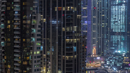 Aerial view of Dubai Marina residential and office skyscrapers with waterfront night timelapse