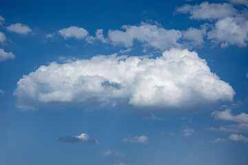 White cloud floating above textured blue sky with lower cloud layer