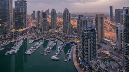 Aerial top view of Dubai Marina night to day timelapse. Modern towers and traffic on the road
