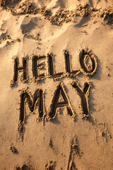 Fototapeta premium HELLO MAY Drawn in Playful Letters in Wet Sand with Clean Texture and Warm Light