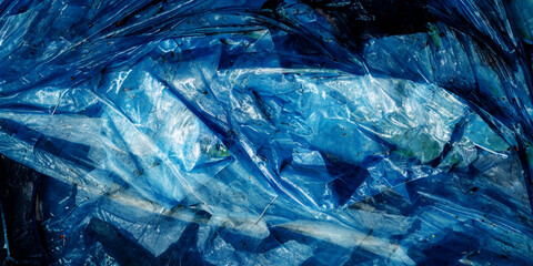 Obraz premium Wrinkled blue plastic sheet, showing detailed texture and patterns. Suitable as an abstract background or for illustrating themes of plastic pollution, waste management, and environmental issues