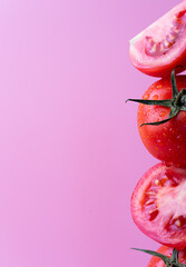 Stack of fresh whole and halved tomatoes with water droplets on pink background. Vibrant and healthy food concept with copy space for creative design.